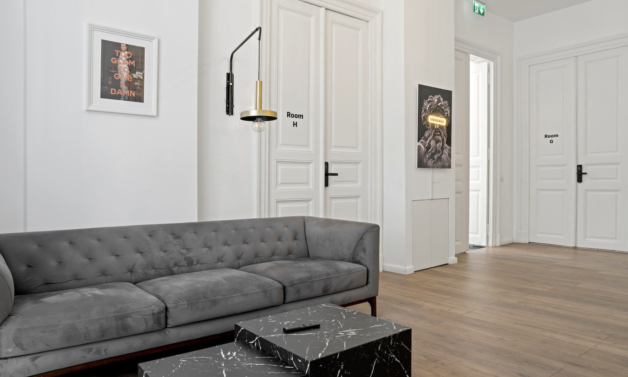 The lounge at Nest Boutique Hostel — velvet sofa, marble tables and neon artwork